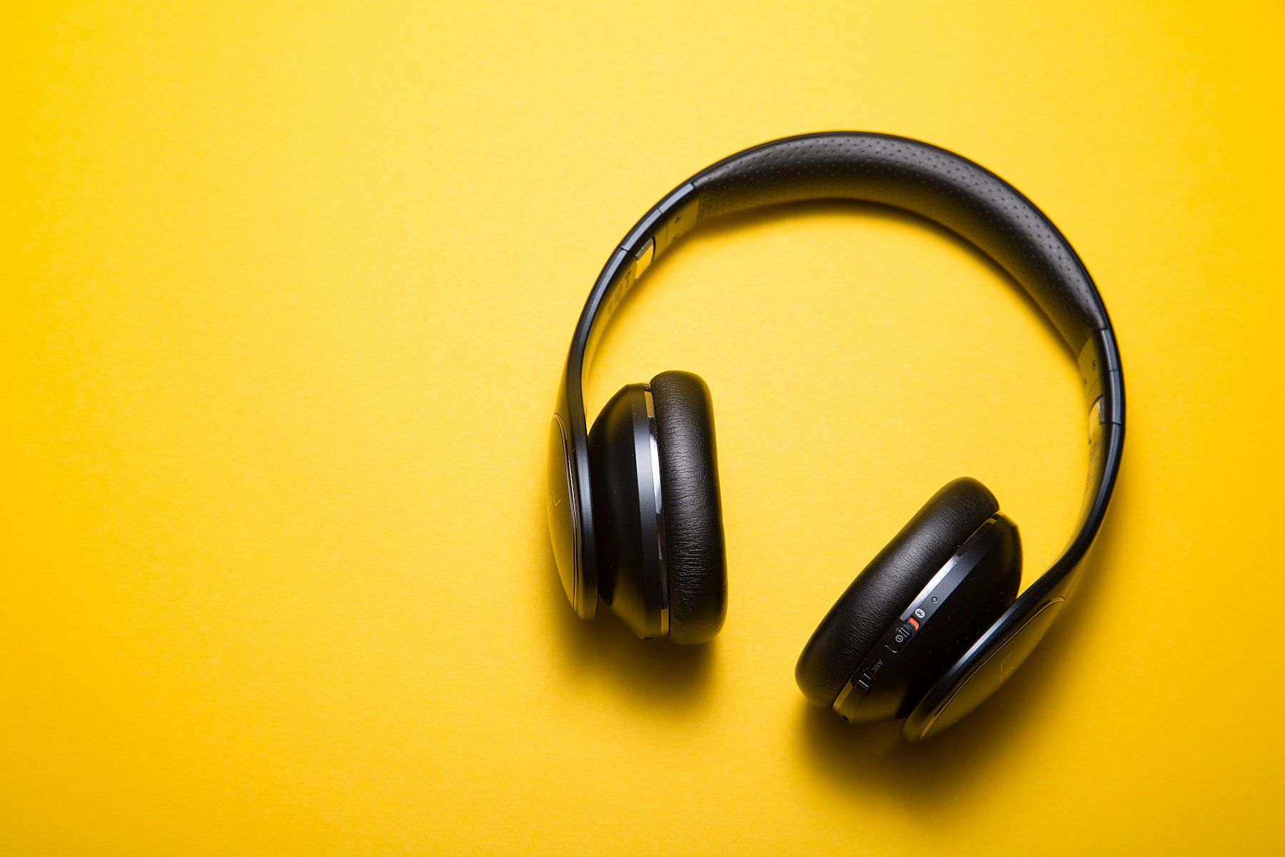 AURIS One: black over-ear headphones on a yellow field, industrial product page.