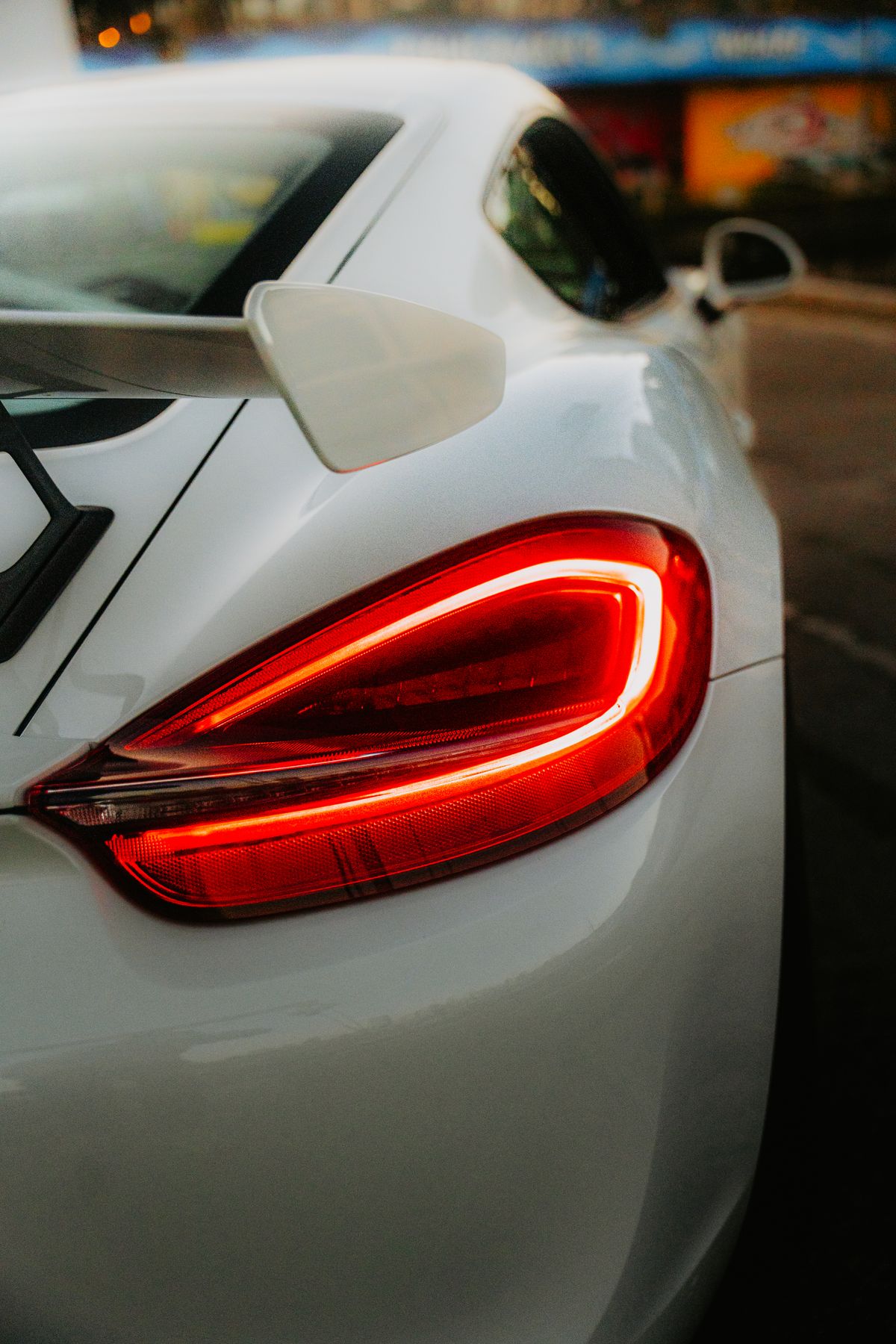 The rear lamp of the K8 Aviator lit at dusk, its sculpted housing catching the last light.
