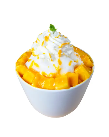 A bowl of shaved ice topped with cubes of fresh mango and cream.