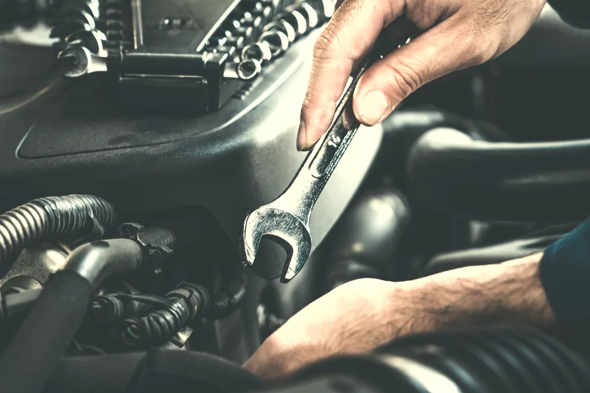 Technician working on an engine with a spanner