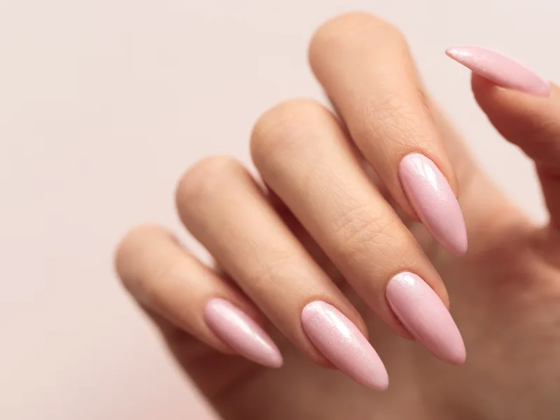 Long almond-shaped nails in a soft pink gel finish.