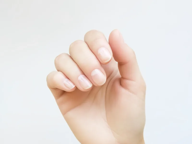 A hand with short, buffed natural nails.