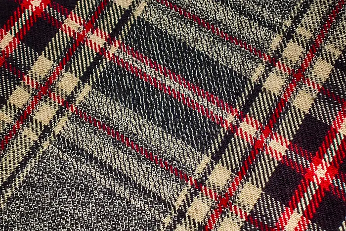 Grey herringbone cloth with a red, black and cream overcheck.