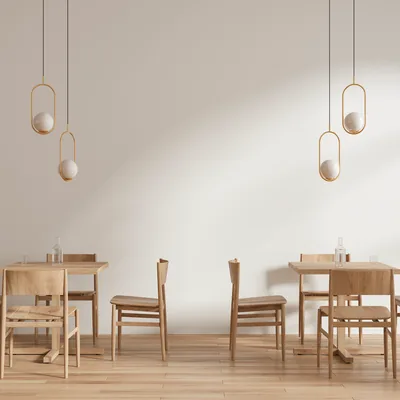 A bright dining room with pale walls and simple wooden tables.