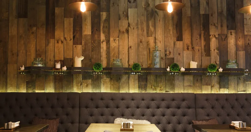 A vintage wood-panelled cafe interior with open shelving and hanging lights.