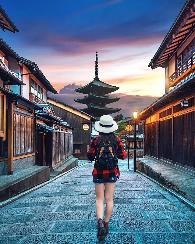 A traveller walking the Ninenzaka lane toward Yasaka Pagoda at dawn